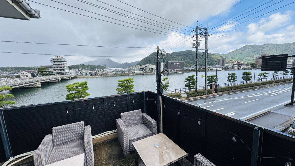 「バイクヤノニカイ」入口のベンチと松本川